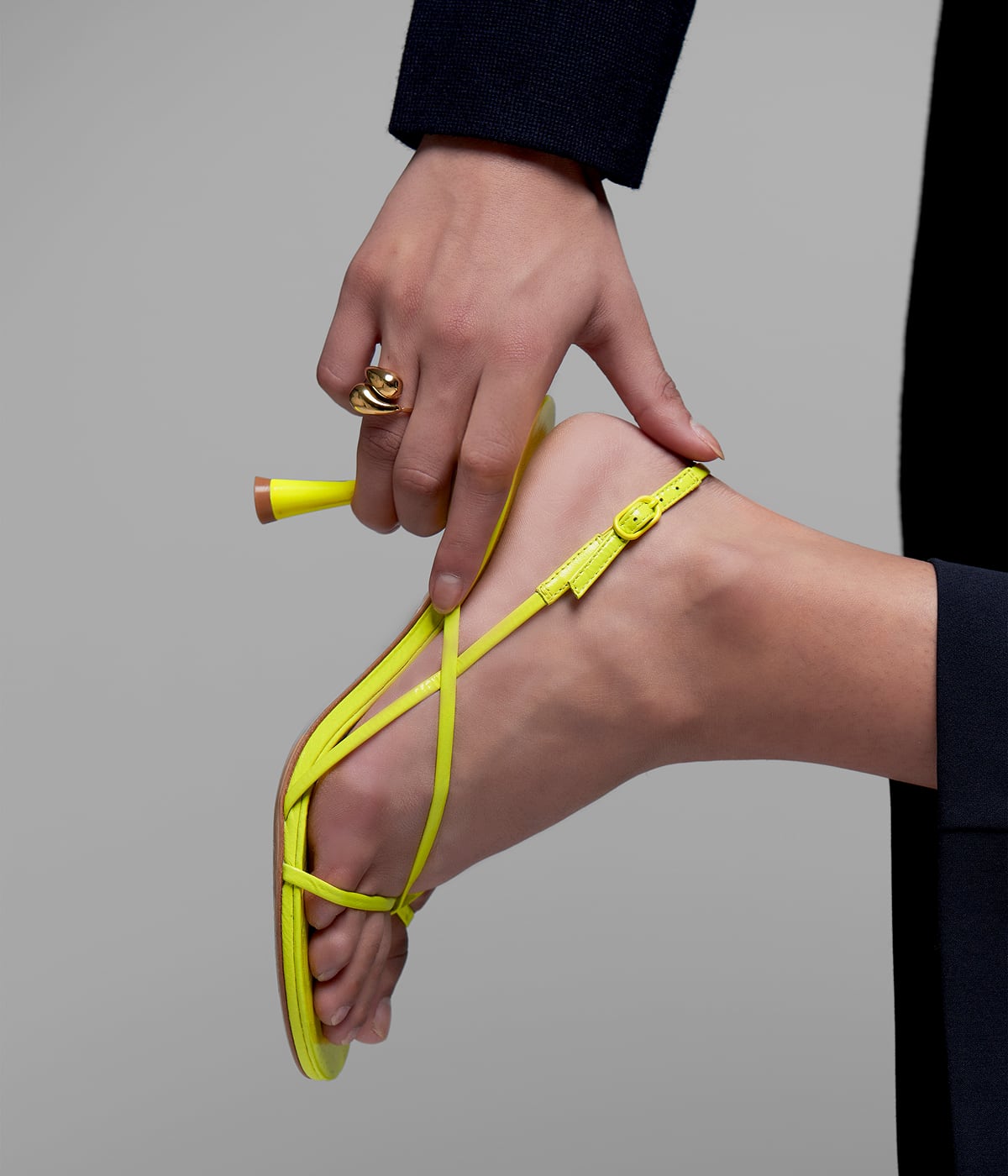 Macro di una scarpa con tacco indossata, con una mano che sfiora il tallone. Il prodotto prende vita: esperienza tattile, identità digitale e tracciabilità