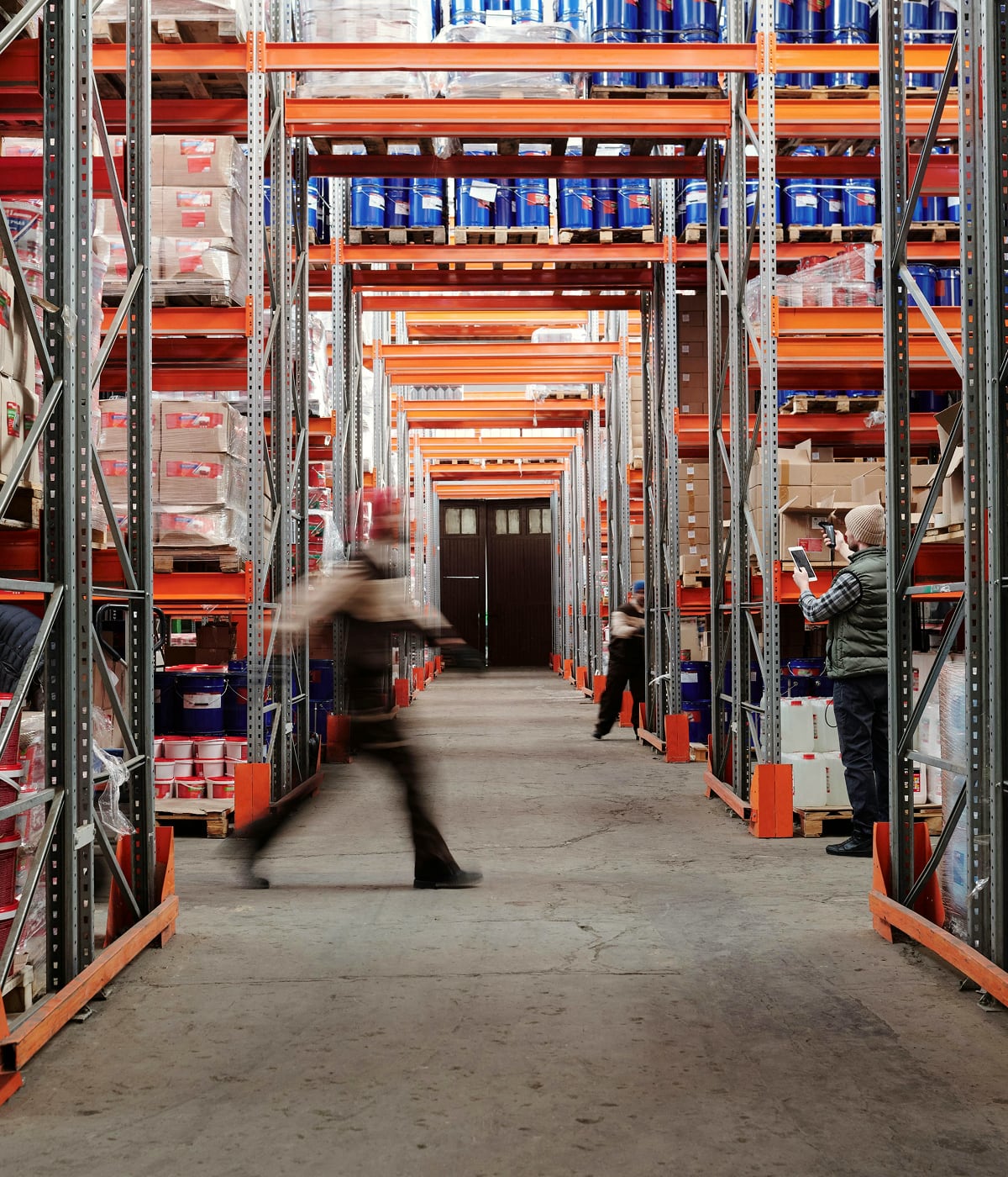 Uomo che si muove con determinazione in un magazzino logistico, dove l'innovazione di Temera ottimizza ogni operazione. Con il sistema RFID, ogni prodotto