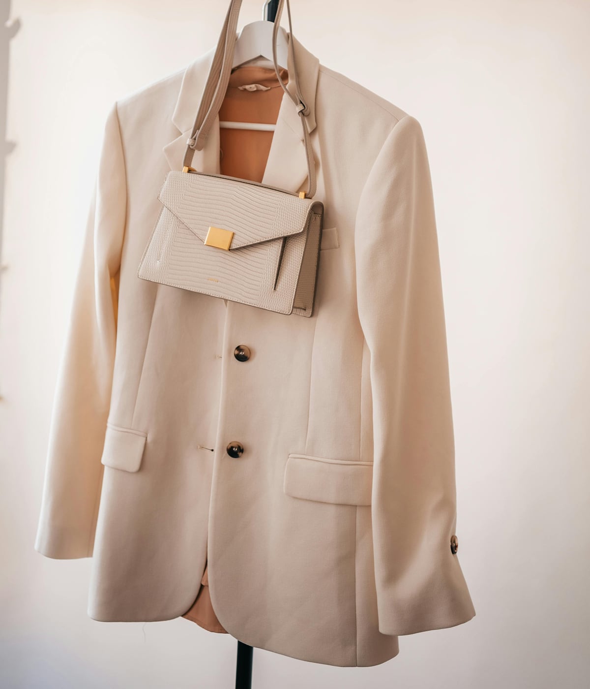 Un blazer e una borsa appesi, simbolo di eleganza e qualità. Grazie alla tecnologia RFID di Temera, ogni prodotto è tracciato in modo preciso, garantendo t